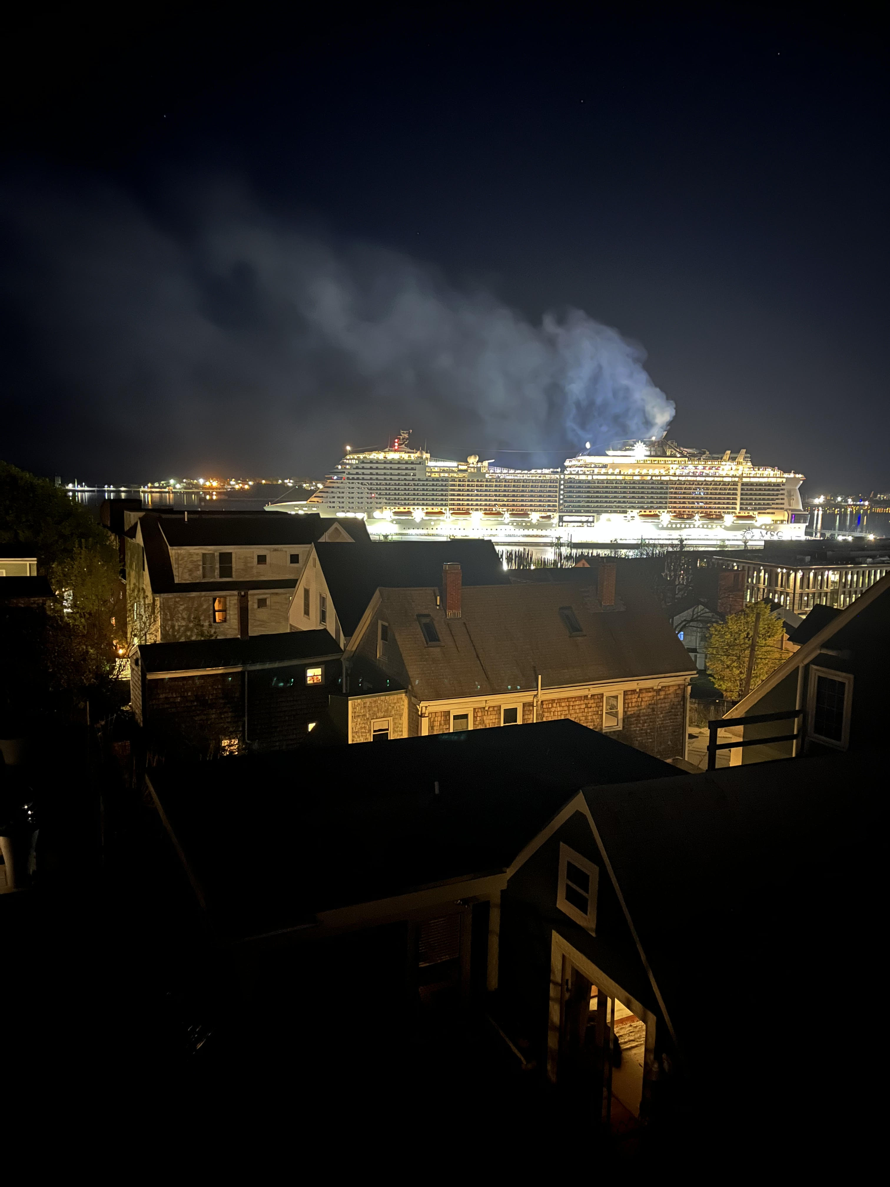 Cruise ship at night with visible pollution from scrubbers